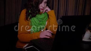 年轻漂亮的女孩坐在咖啡馆的桌子上，喜欢笔记本电脑。 她`很<strong>专注</strong>。 特写镜头。